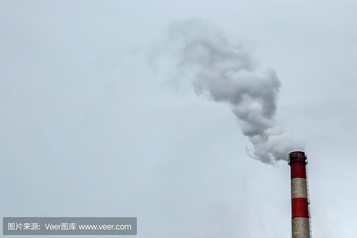 从烟囱里冒出的烟映衬着灰色的天空。空气污染的概念,二氧化碳,二氧化碳气体,废气。