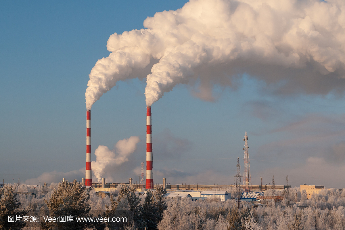 火电站高层管道冒出白色浓烟。在霜冻的冬日,白色的蒸汽映衬着蓝色的天空。