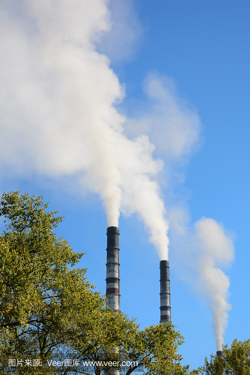 烟囱冒着烟,映衬着蓝天。环境污染,生态问题。